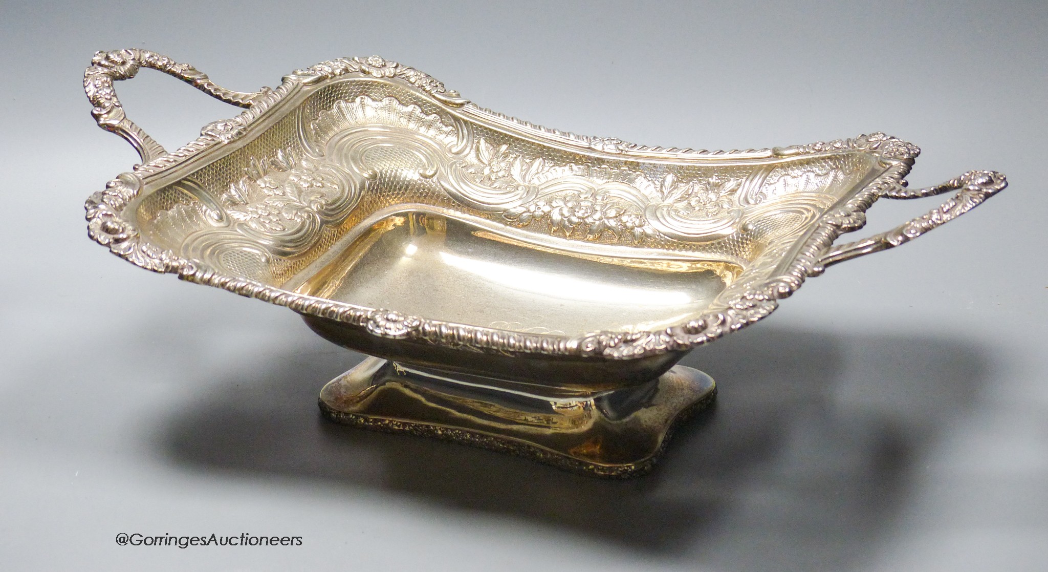 A late George III silver two handled bread dish, embossed with foliate scroll decoration, by Charles Price, London, 1817, 39.5oz.
